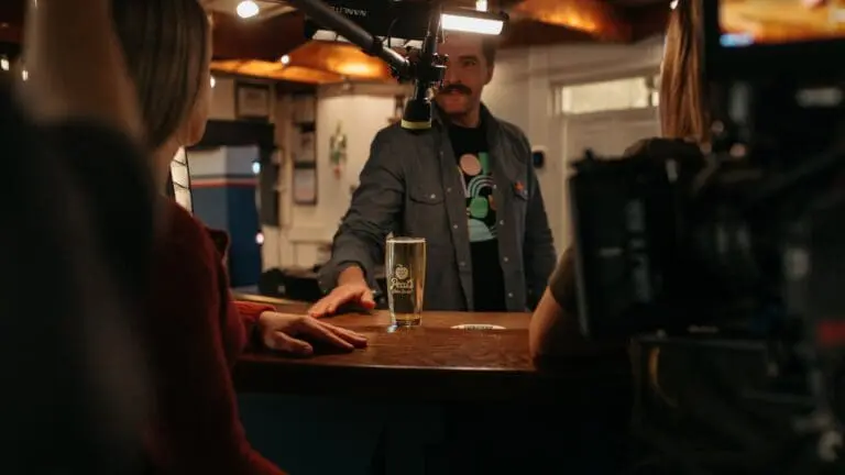 bartender placing cider on bar for woman to drink
