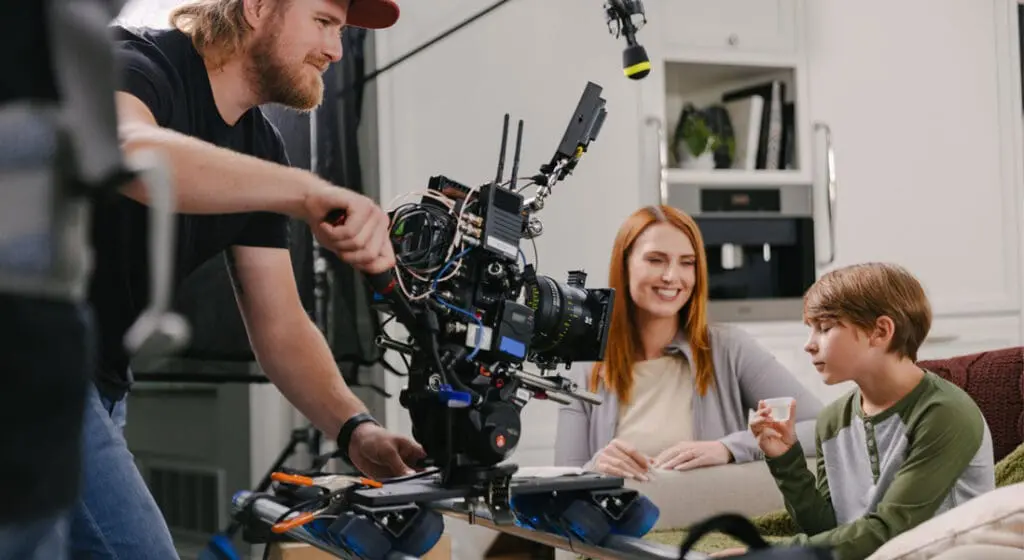 JV studios crew member filming mother and son on a couch