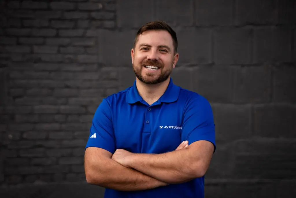 Male with big smile wearing blue jv studios polo