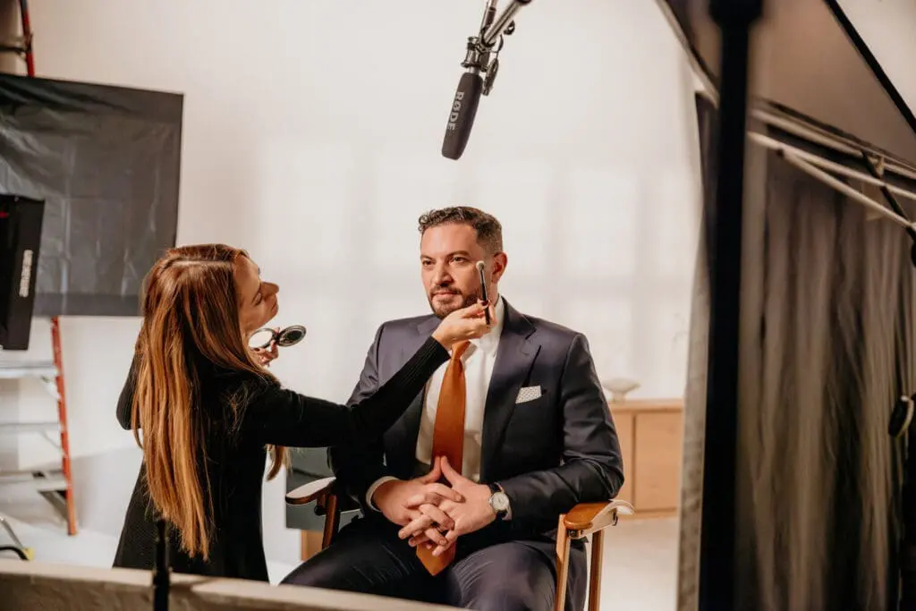 man getting his makeup touched up for a commercial