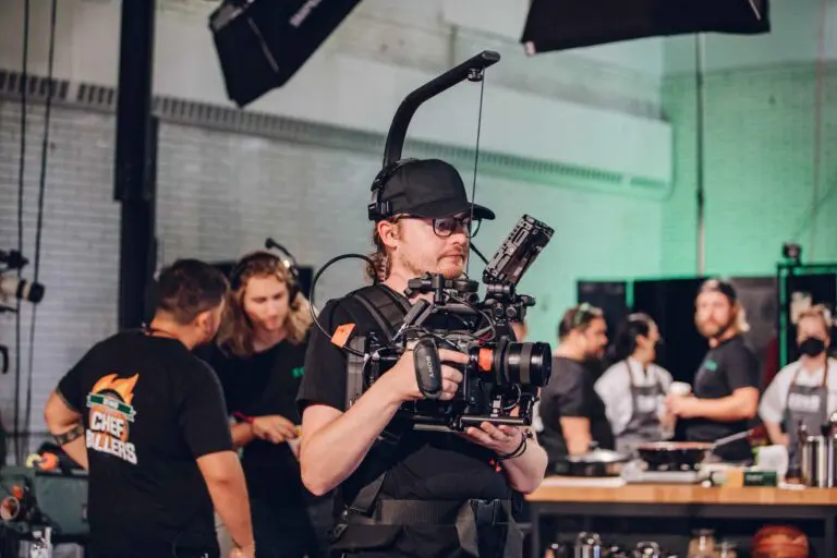 A professional video production camera and crew on a commercial set, representing the high-quality equipment used by JV Studios.
