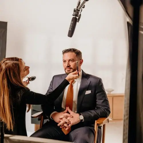 man getting his makeup touched up for a commercial