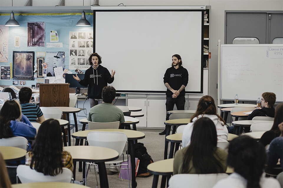 the jv studios team speaking in a classroom at a school