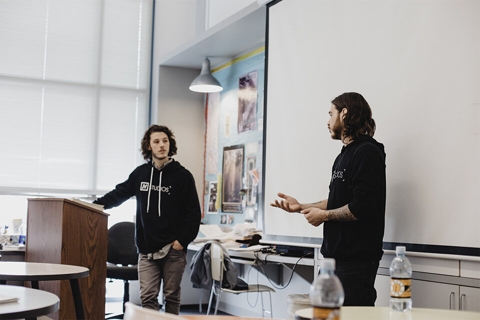 the jv studios team speaking in a classroom at a school