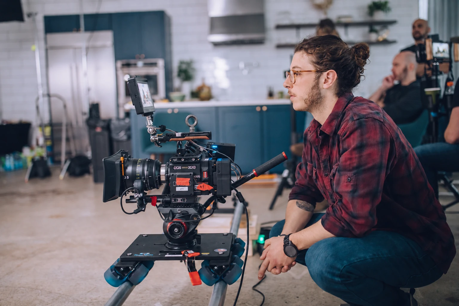 JV Studios filmmaker operating a cinema camera and monitor on a kitchen commercial set