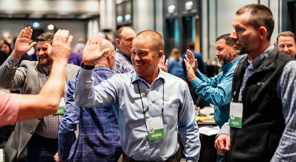 conference-coverage man at a conference, high-fiving somebody